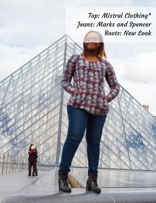 Me standing in one of my favourite winter fashion looks: a multicoloured top from Mistral Clothing*, a pair of jeans and my biker boots.