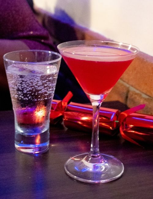 A photo of a cosmopolitan, sprite and a red Christmas cracker from Sage & Chilli
