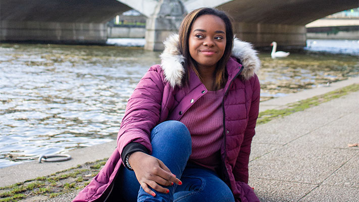 photo of author, Jasmine Burke, sitting on the ground, smiling and thinking about the new year