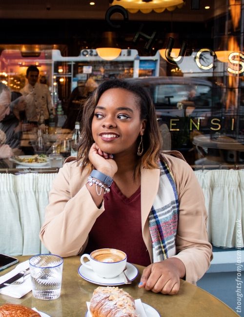 Photo of me sitting in cafe in beige trench coat and scarf