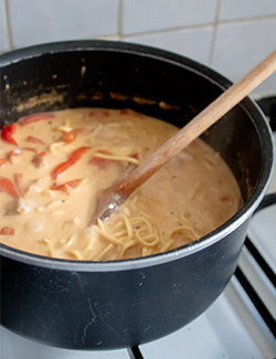 A photo of the laksa in a pot being stirred