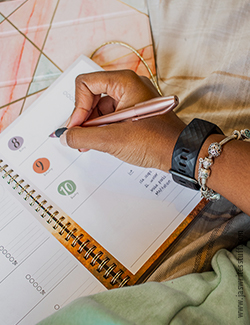 a photo of a hand writing in a 2021 diary