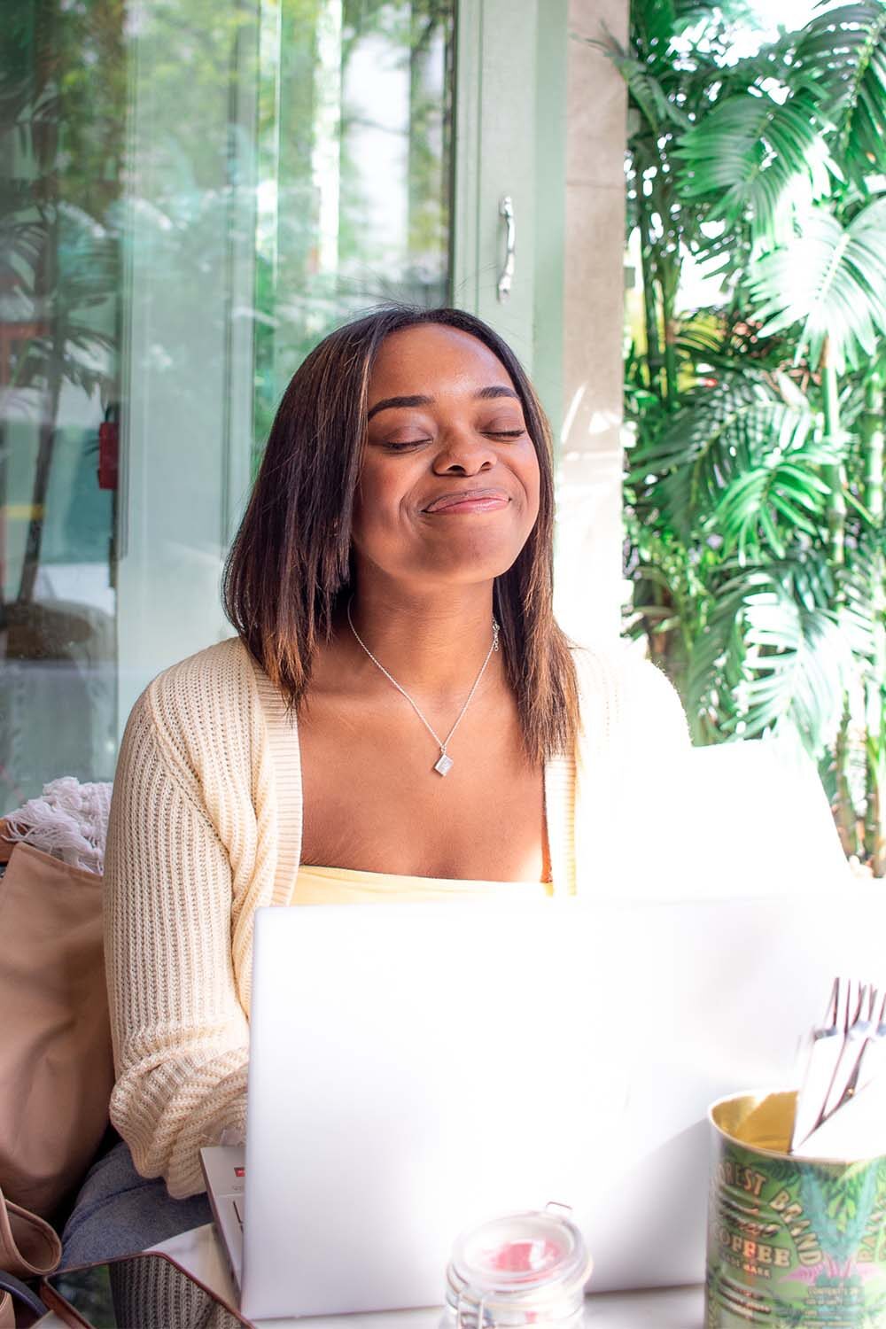 Author, Jasmine Burke, smiling at camera while typing on laptop