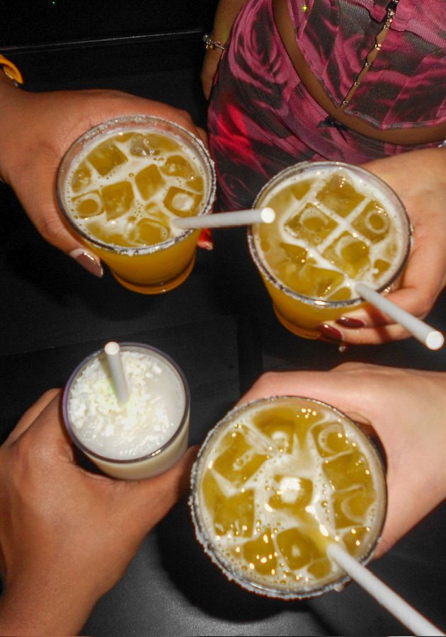 A photo of four friends cheersing different drinks
